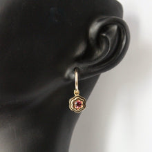 Load image into Gallery viewer, Gold floral earring with a pink gemstone modeled on an ear against a black background