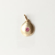 Load image into Gallery viewer, 14k yellow gold round charm with a pink spinel set in the middle shown on a light grey background. Talayee Fine Jewelry's Suri Charm.