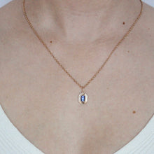 Load image into Gallery viewer, talayee fine jewelry's persepolis pendant with an emerald cut tanzanite set in 14k gold modeled on figure