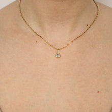 Load image into Gallery viewer, 14k yellow gold charm set with a round gray spinel, worn on a barleycorn chain, shown on figure.