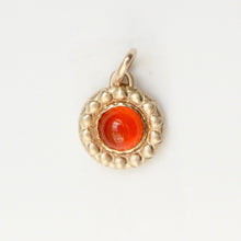 Load image into Gallery viewer, A round gold pendant featuring a textured raised border and a central carnelian cabochon gemstone, shown on a plain white background. Talayee Fine Jewelry's Atousa Medallion Pendant.