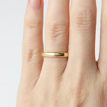 Load image into Gallery viewer, 14k Gold beveled ring on a person's finger against a light background