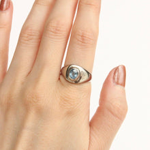 Load image into Gallery viewer, 14k white gold ring with 1.2ct icy blue montana sapphire on figure against a white background. Talayee Fine Jewelry's signature Persepolis Signet Ring