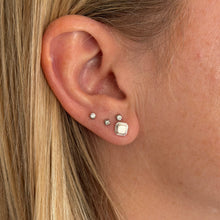 Load image into Gallery viewer, Close-up of an ear wearing silver geometric stud earrings by talayee fine jewelry
