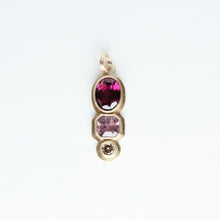 Load image into Gallery viewer, A three gemstone pendant featuring a rhodolite garnet, pink spinel, and champagne diamond in 14k yellow gold.
