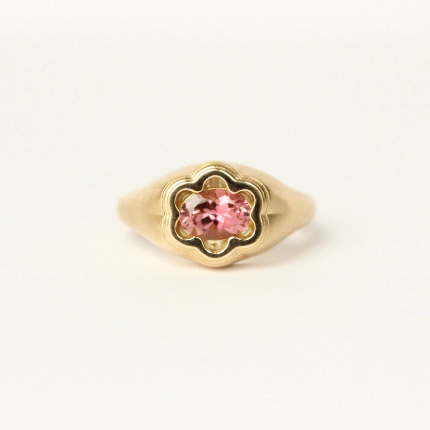 Talayee Fine Jewelry's one of a kind Bloom Ring. 18k gold ring with a oval pink Tourmaline set in a floral setting shown on a white background.
