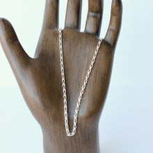 Load image into Gallery viewer, Silver chain necklace on a wooden mannequin hand against a white background
