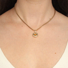 Load image into Gallery viewer, Talayee Fine Jewelry&#39;s Bloom Pendant. 18k yellow gold pendant with an orange garnet set in a floral style setting styled on a snake chain shown on figure.
