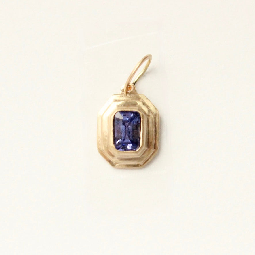 talayee fine jewelry's persepolis pendant with an emerald cut tanzanite set in 14k gold shown on a white background