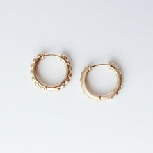 Load image into Gallery viewer, A pair of small gold hoop earrings with a textured, scalloped outer edge, displayed on a clean white background. Talayee Fine Jewelry's Atousa Huggie Hoop Earrings.
