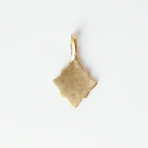 14k gold charm in a geometric shape on a light gray background.