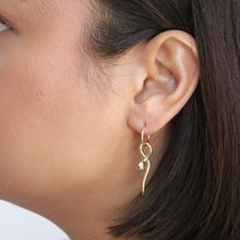 Load image into Gallery viewer, 10k huggie hoop earrings with snake charm on figure. Taylor Swift Reputation Snake Earrings.
