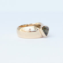 Load image into Gallery viewer, A 14k yellow gold cigar band style ring featuring a trillion cut teal sapphire in a bezel setting, shown on a clean white background.
