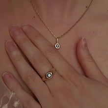 Load image into Gallery viewer, 14k yellow gold and gray spinel ring and pendant styled on figure
