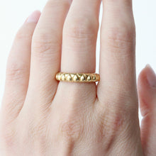Load image into Gallery viewer, A gold band ring with a textured raised pear shape pattern, photographed on hand against clean white background. Talayee Fine Jewelry's Atousa Ring
