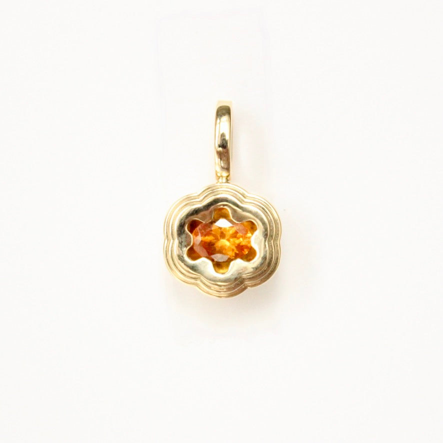 Talayee Fine Jewelry's Bloom Pendant. 18k yellow gold pendant with an orange garnet set in a floral style setting shown on a white background.