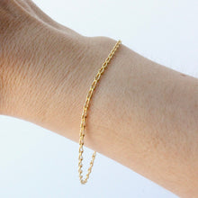 Load image into Gallery viewer, 14k gold infinity chain bracelet shown on wrist against a white background
