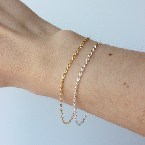 14k gold and silver infinity chain bracelet shown on wrist against a white background