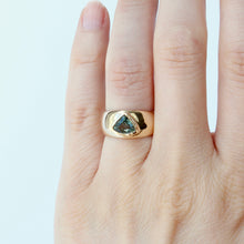 Load image into Gallery viewer, A 14k gold cigar band style ring with a trillion cut sapphire shown on hand
