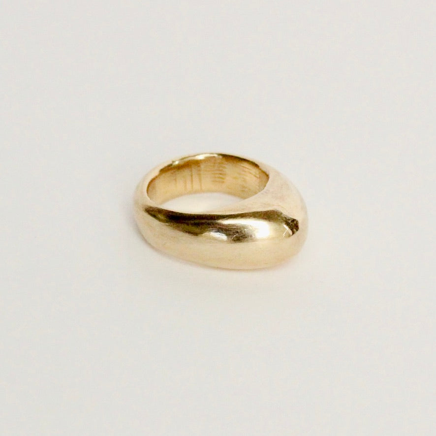 14k yellow gold domed statement ring on white background. Prounis chunky band.